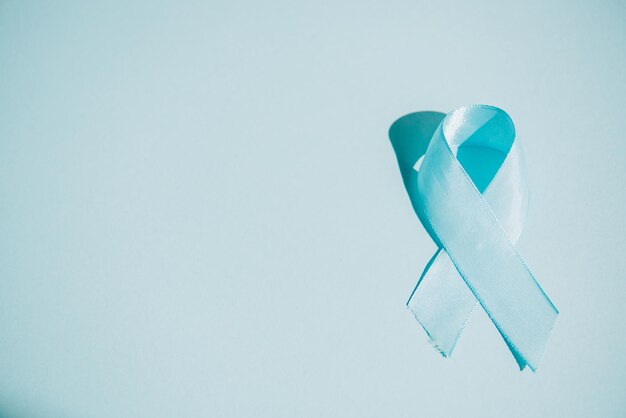 Blue awareness ribbon on white background with copy space