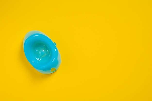 Blue baby potty on a yellow background with copy space Children plastic toilet