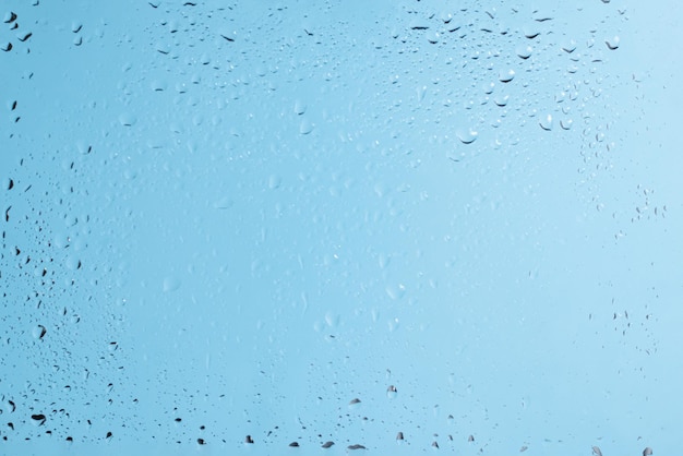 Blue backgrond with water drops. Wet glass.  Copy space.