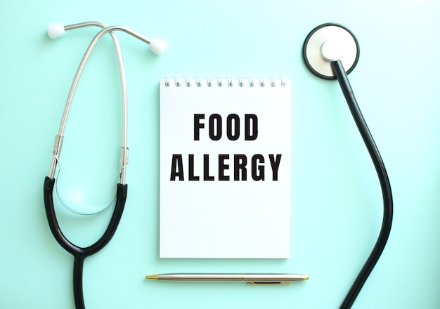 青い背景に、聴診器とFOODALLERGYという言葉が書かれた白いメモ帳