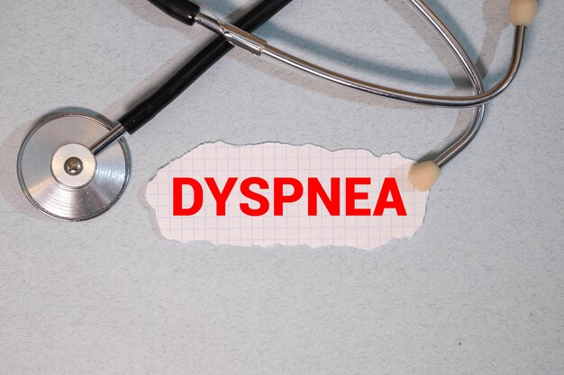 青い背景のステトスコープと木製のブロックに DYSPNEAという言葉が書かれています