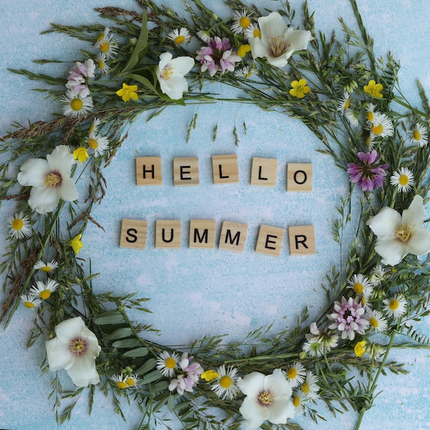 blue background with flowers frame and text hello summer