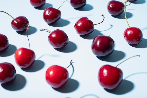 Blue background with red cherries close up