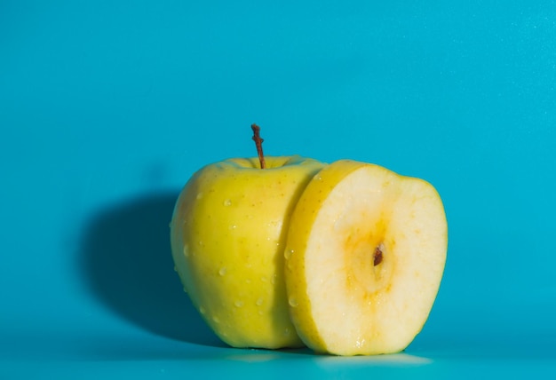 On a blue background yellow Apple, close up.