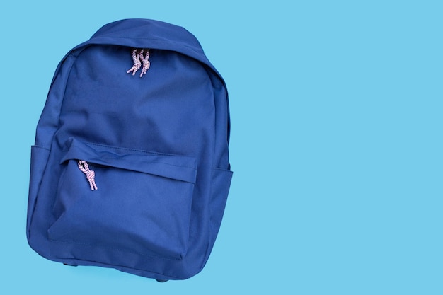 Photo blue backpack on blue background copy space
