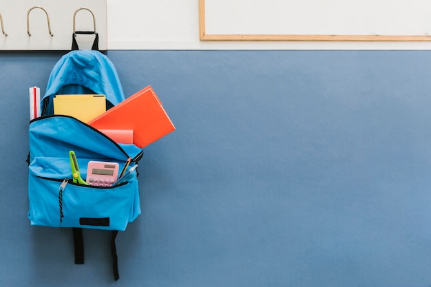 Blue backpack on hook in school