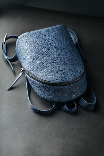 Blue backpack made of genuine leather on dark