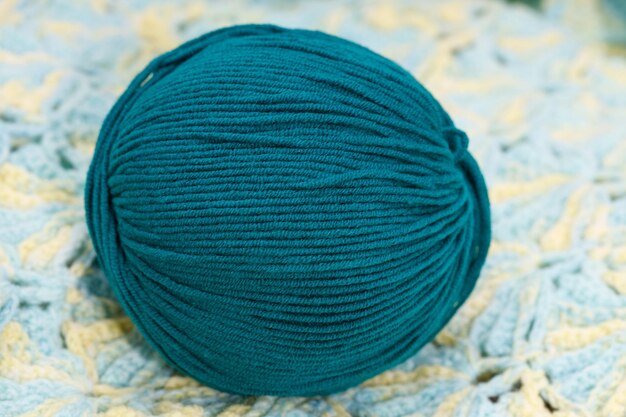 Blue ball of wool lies on a knitted napkin. High quality photo