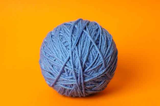 Blue ball of yarn on orange background