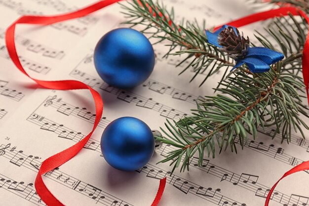 Blue balls on music sheet. Christmas songs concept