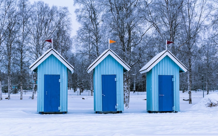Photo blue beach huts in the snow with snow on the ground