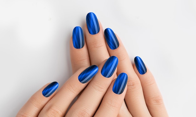 Blue and black on nails young lady hands with manicured nail art design blue color nails