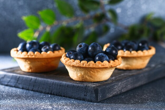 Blue blackthorn berries in sand tartlets on a table.