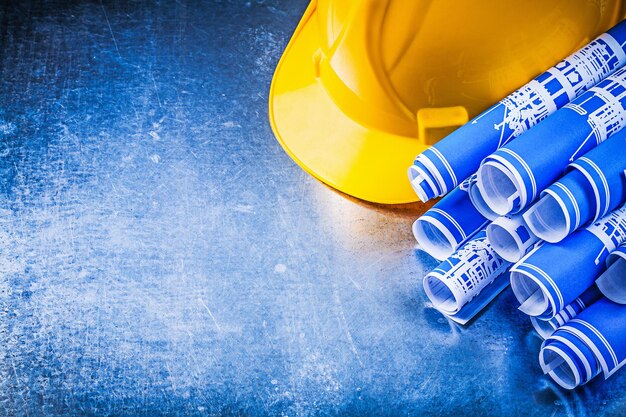 Photo blue blueprints hard hat on metallic background construction concept