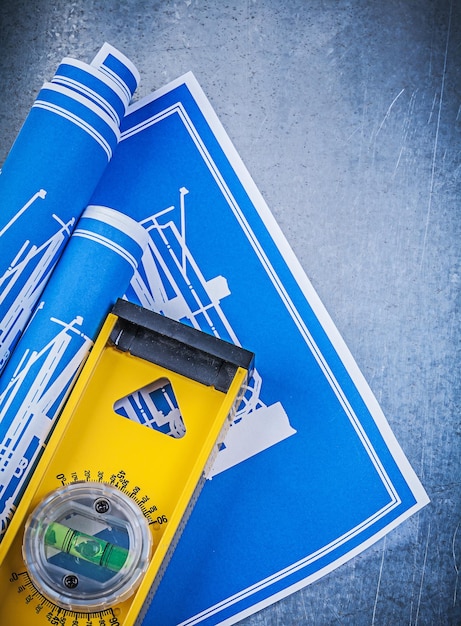 Blue blueprints yellow construction level on metallic background