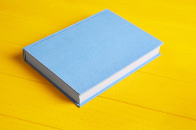 Blue book on yellow wooden table