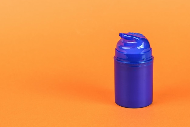 A blue bottle of aftershave gel on an orange background