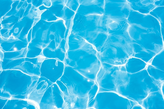 Blue and bright water surface and ripple wave with sun reflection in swimming pool