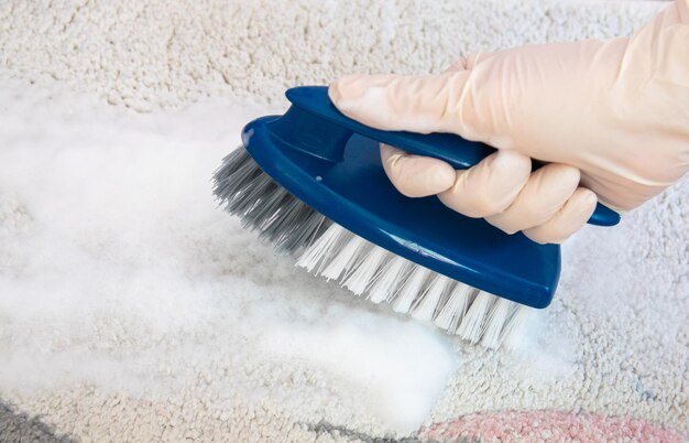 Blue brush on the floor with hand Cleaning