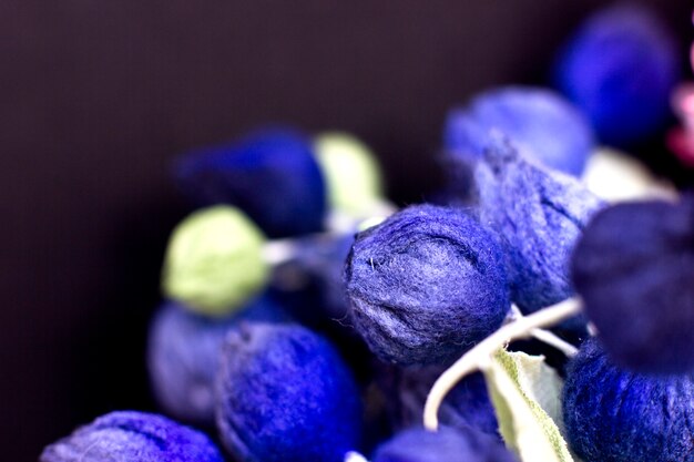 Blue buds and pink lilacs on a black background. Artificial flowersb