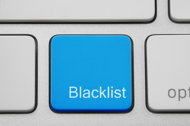 Photo blue button with word blacklist on computer keyboard closeup