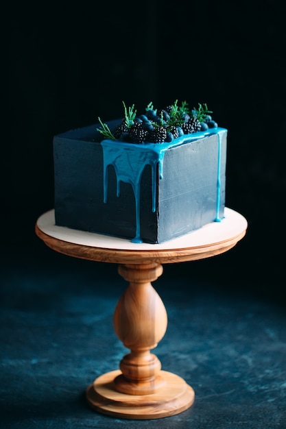 ブラックベリーとブルーベリーで飾られた青いケーキ。