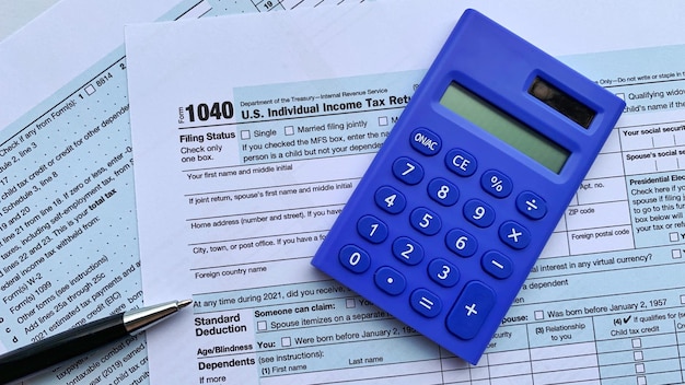 Blue calculator on US individual tax form Copy space concept