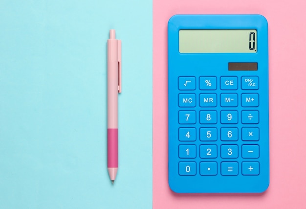 Blue calculator with pen on pink blue.