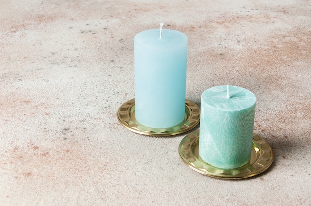 Blue candles on brass candlesticks, coasters, small dishes on concrete