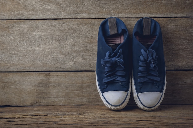 Blue canvas shoes on wooden background 