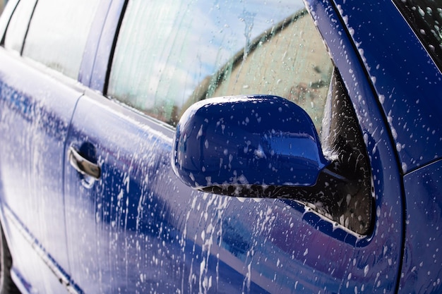 Blue car in foam at a car wash