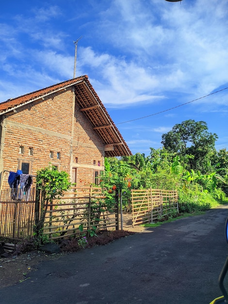 A blue car is parked in front of a house