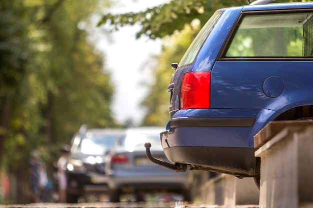 写真 日当たりの良い通りに駐車した青い車、赤い停止信号、トレーラーをドラッグするためのフック