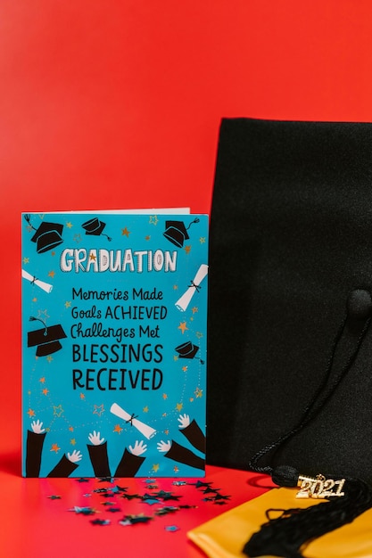 Blue Card Beside Black Graduation Cap Stock Photo