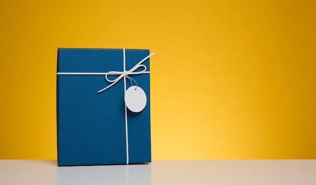 Blue cardboard gift box on yellow background