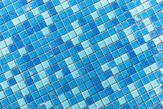 Blue ceramic mosaic in the pool. Laying small tiles in the pool. Close-up background. Construction work in the pool.