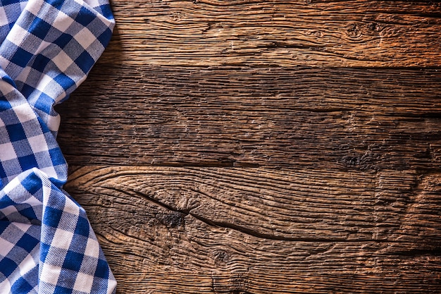 Blue checkered kitchen tablecloth on rustic wooden table.