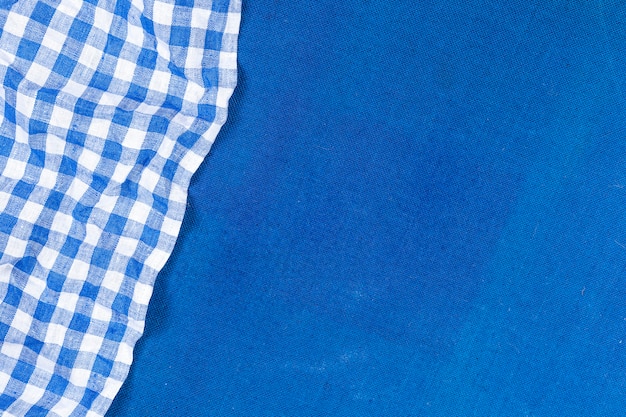 Foto tovagliolo a quadretti blu sul fondo blu del panno, vista superiore