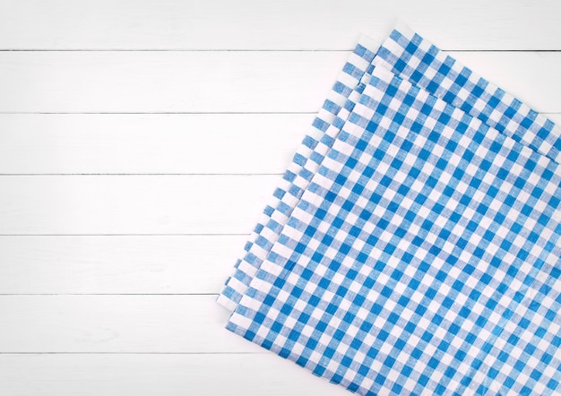 Blue checkered tablecloth on white wooden table