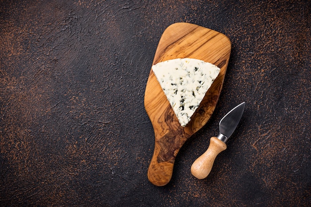 Blue cheese and knife on cutting board