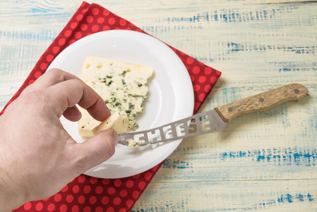 Blue cheese A man's hand takes a piece of cheese