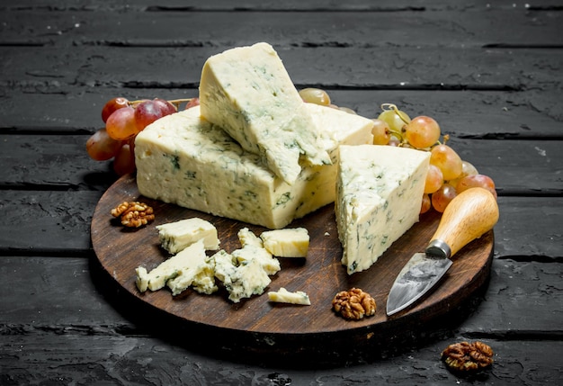 Blue cheese on a wooden board with grapes