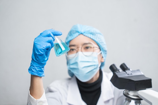 Blue chemical liquid experiment in scientific glassware equipment in science medicine laboratory chemistry or biology research discovery by using glass of test tube or beaker and flask