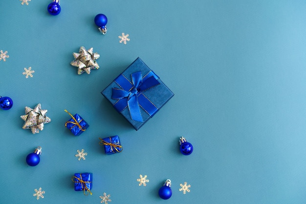 Blue christmas background of gift box and snowflake decorations and balls of blue and silver color w...