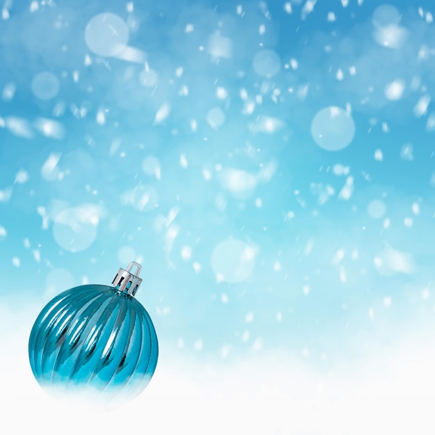 Blue christmas ball on blue background with falling snow