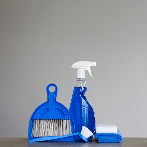 Blue cleaning kit: Spray detergent, dishwashing brush, dust cloths, sponge, scoop and broom. copyspace.