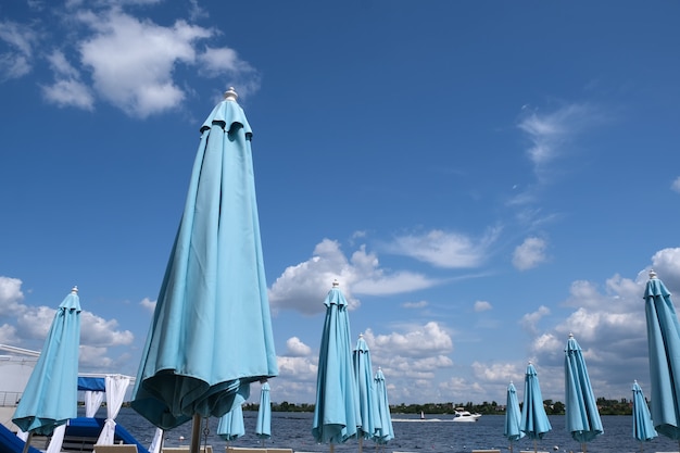 Photo blue closed stationary beach umbrellas