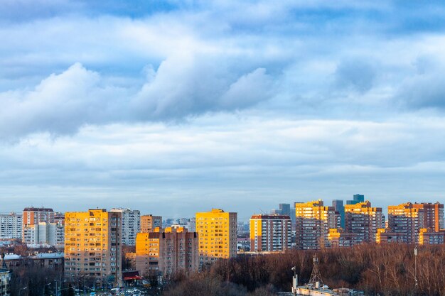 Nuvole blu sopra le case urbane al tramonto di primavera