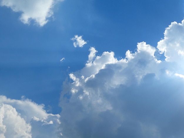 The blue cloudy sky with white clouds background and texture