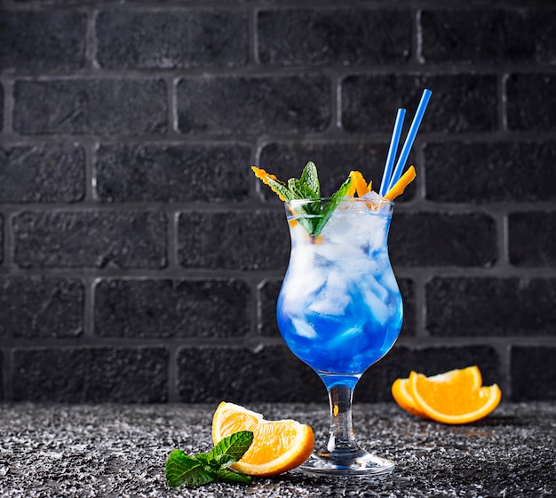 Blue cocktail drink with ice and orange